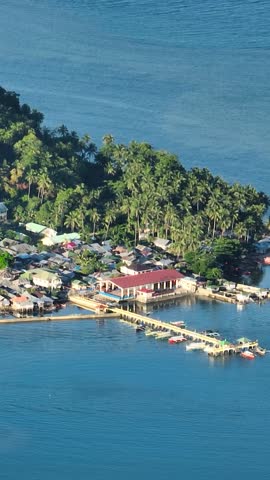 Stilt houses and blue sea in tropical island. Mindanao, Philippines. Zoom view. Vertical, stories.