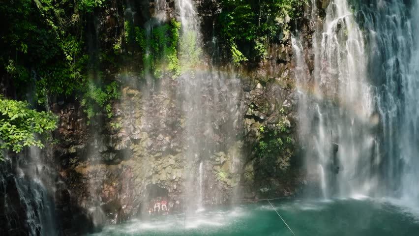 Tinago Falls with trees and natural foliage. Mindanao, Philippines. Slow motion.