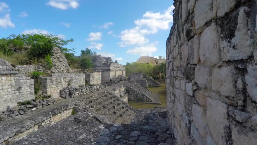 A smooth gimbal shot captures the ancient Mayan ruins at Ek Balam near Cancun, Mexico, showcasing historical architecture, archaeological significance, and cultural heritage in a scenic setting.