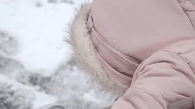 Child playing in snow during winter in a cozy pink jacket - Powered by Shutterstock - Get 15% off with code: PIKWIZARD15