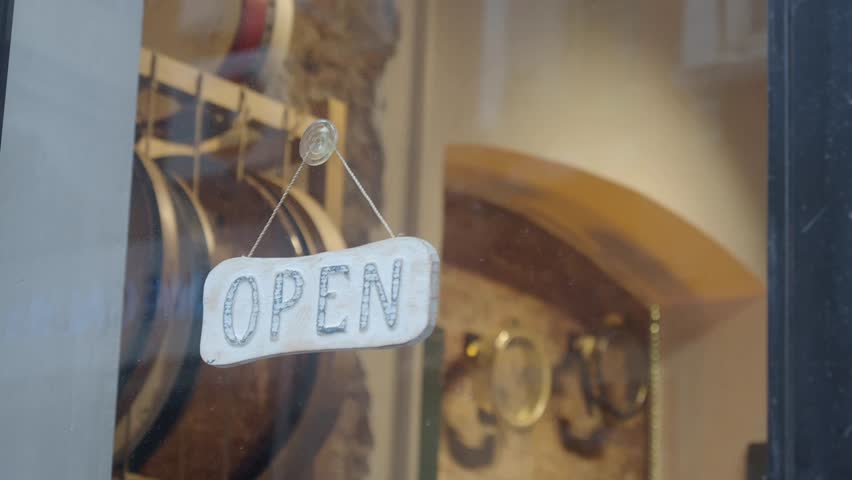 Cafe features open sign to welcome customers in bustling neighborhood