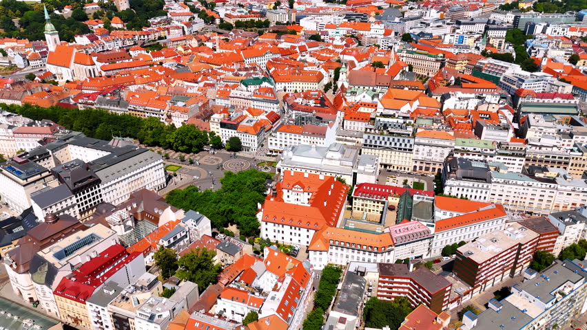 Stunning densely built historical part of Bratislava, Slovakia. Sunny scenery of old town with orange roofs from drone.