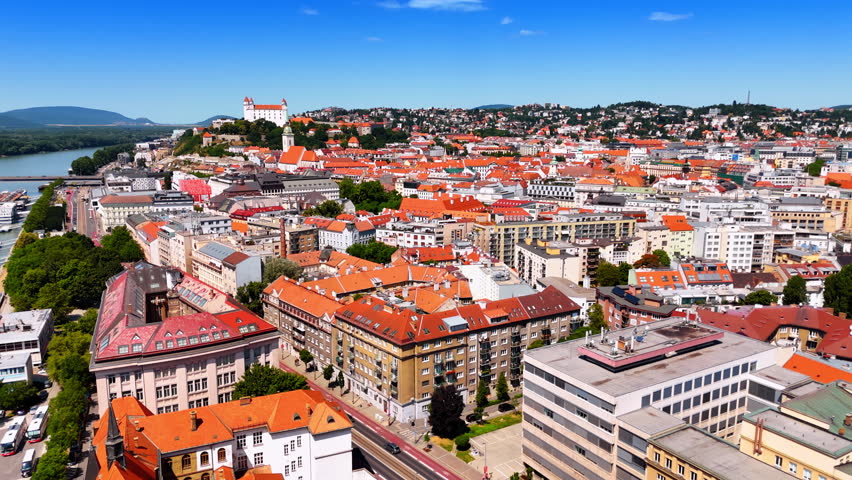 Sunny panorama of old town of Bratislava, Slovakia. Drone footage above the watrfront of the Danube.