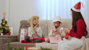 Happy family celebrating christmas holiday at home, kids wearing cozy winter hats unwrapping presents near decorated tree, parent wearing santa hat enjoys joyful festive season with children. - Powered by Shutterstock - Get 15% off with code: PIKWIZARD15