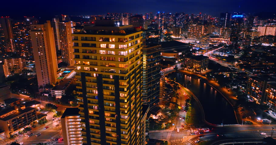 Modern high-rise buildings with lights on in the windows. Night scenery of Waikiki, Honolulu, Hawaii, USA. Aerial view.