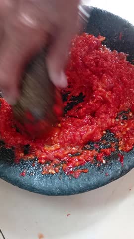 a mother is making very fine chili sauce