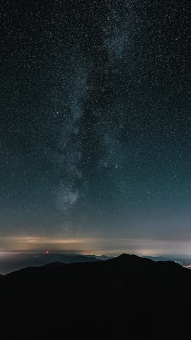 Milky Way Galaxy Over Mountains and City Lights in Valley, Vertical Time Lapse