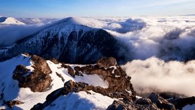 Winter Mountain morning Peak Above Sea of Moving Clouds Snowy Rocks and Fog Time Lapse  - Powered by Shutterstock - Get 15% off with code: PIKWIZARD15