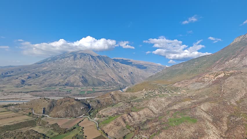 Aerial view of Albania scenic mountains, valleys, and untouched nature. Rugged terrain with lush greenery and dramatic elevation under clear skies