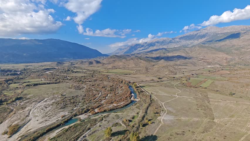 Aerial view of Albania scenic mountains, valleys, and untouched nature. Rugged terrain with lush greenery and dramatic elevation under clear skies