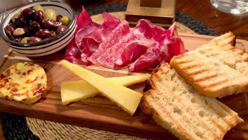 charcuterie board of sourdough bread cheese olives and cured salami meat platter