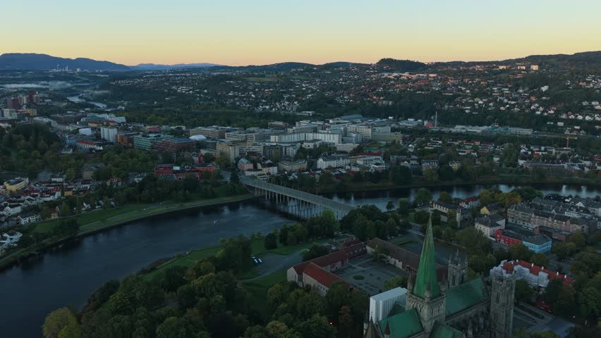 Drone view of Trondheim homes at sunrise with warm early light in Norway