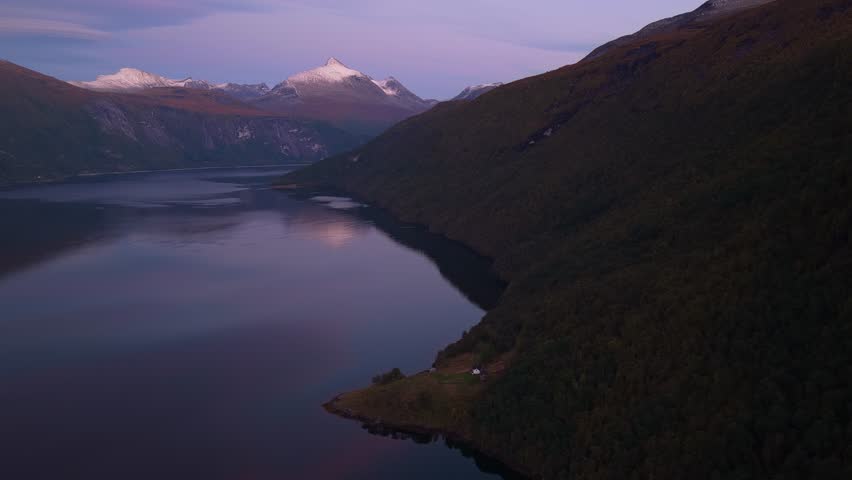 High angle of cabin near Langfjorden bathed in warm sunset tones