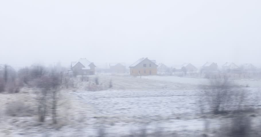 Snowy Rural Landscape with Houses in Winter Fog