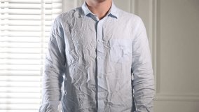 Man putting on creased shirt indoors, closeup - Powered by Shutterstock - Get 15% off with code: PIKWIZARD15