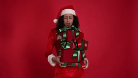 Surprised woman in Mrs Claus costume dropping Christmas gifts on red background - Powered by Shutterstock - Get 15% off with code: PIKWIZARD15