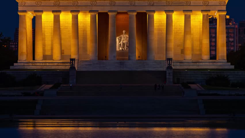 Washington DC. A nighttime photograph of the Lincoln Memorial in Washington, DC. The photograph is taken from a low angle, capturing the grandeur of the building with its illuminated columns.