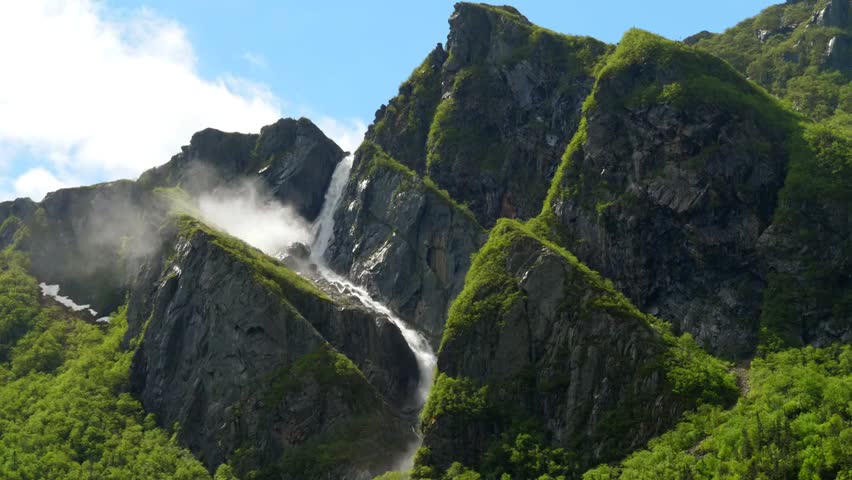 A massive waterfall cascades into Western Brook Pond in Gros Morne, highlighting breathtaking natural beauty, pristine landscapes, and the majesty of this iconic Canadian wilderness location.