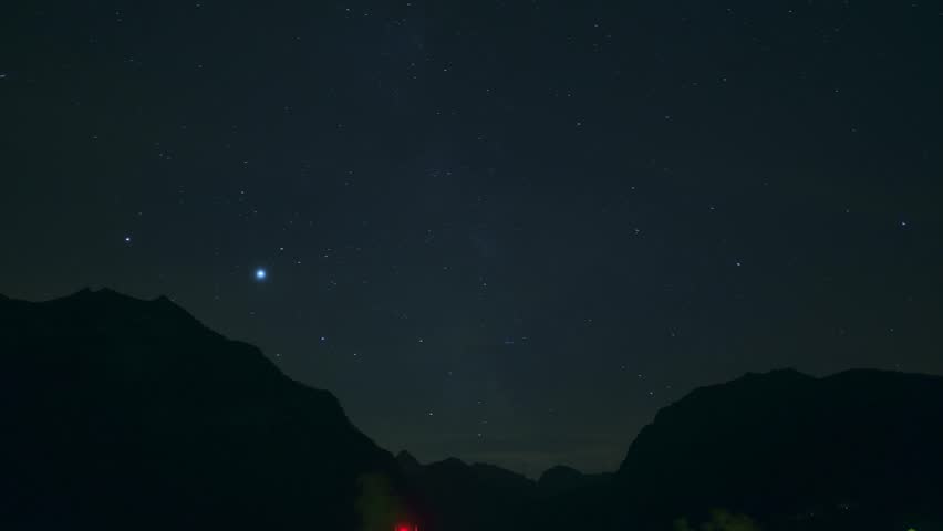 Stunning night sky time lapse showing millions of stars moving over a dark mountain silhouette. A perfect astronomical view of the galaxy in a remote outdoor wilderness.