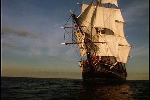 Historical reenactment of HMS Bounty ship on Rhode Island. MS HMS Bounty under full sail in bright sunlight as it turns to face screen left for full side view.