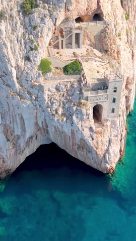  castle nestled on vertical cliffs above serene mediterranean coves near italy. Porto Flavia. vertical video