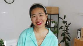 Confident asian woman smiling while looking at the camera in a minimalist bright home office. Concept of empowerment, success and positivity.  - Powered by Shutterstock - Get 15% off with code: PIKWIZARD15