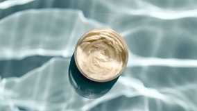 Jar of white cream and reflections sunlight in slow motion. Drop shadow effect with wave refraction of light. Sun and shadows. Layout for advertising goods, cosmetic products. Swimming pool ripples. - Powered by Shutterstock - Get 15% off with code: PIKWIZARD15
