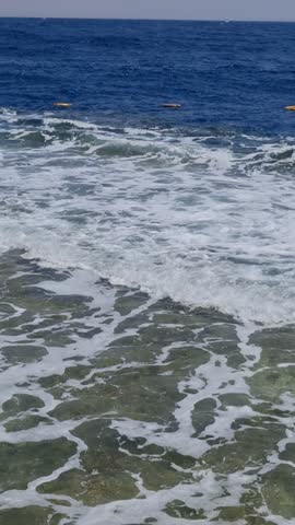 Sharm Elshiek - Sinai - Egypt 08-26-2025 : Rhythmic waves of the Red Sea crashing onto the beach. Clear, turquoise water movement for a peaceful natural background.
