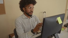 Man using computer in modern office, surrounded by work documents and digital equipment, illustrating a focused professional setting in an indoor workplace environment. - Powered by Shutterstock - Get 15% off with code: PIKWIZARD15