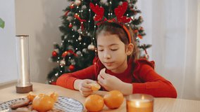 Girl enjoying festive cookies and oranges while celebrating Christmas and New Year near a decorated tree during the holiday season - Powered by Shutterstock - Get 15% off with code: PIKWIZARD15
