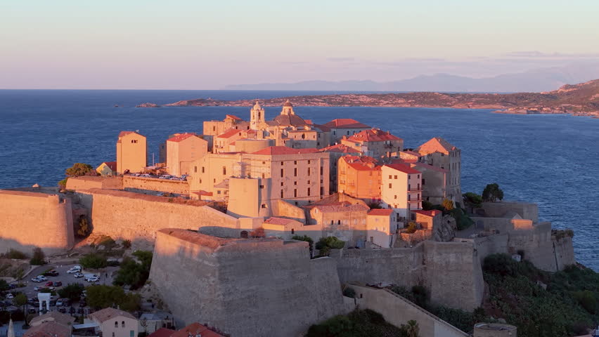 Aerial view of calvi citadel at sunrise with serene waters. Fortress with marina. Corsica. France