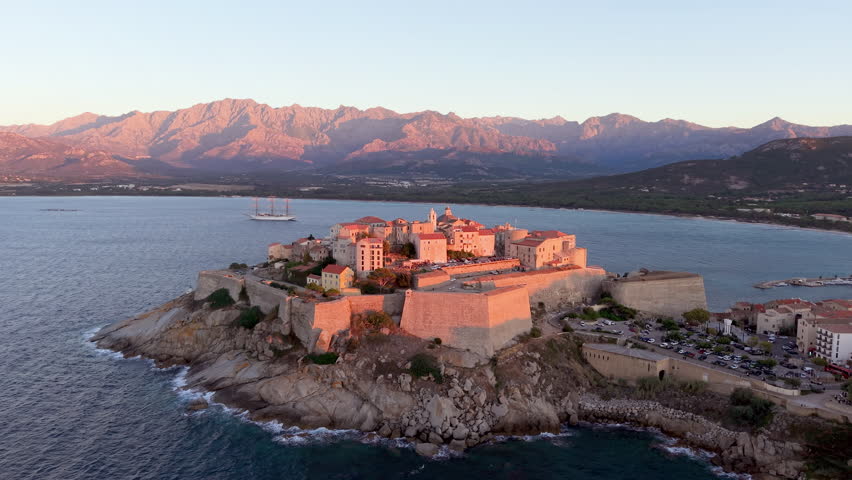 Aerial view of calvi citadel at sunrise with serene waters. Fortress with marina. Corsica. France