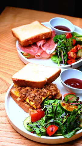 Sandwich plate with salad and sauce. Toasted sandwich served with fresh salad, vegetables and a small bowl of red sauce.