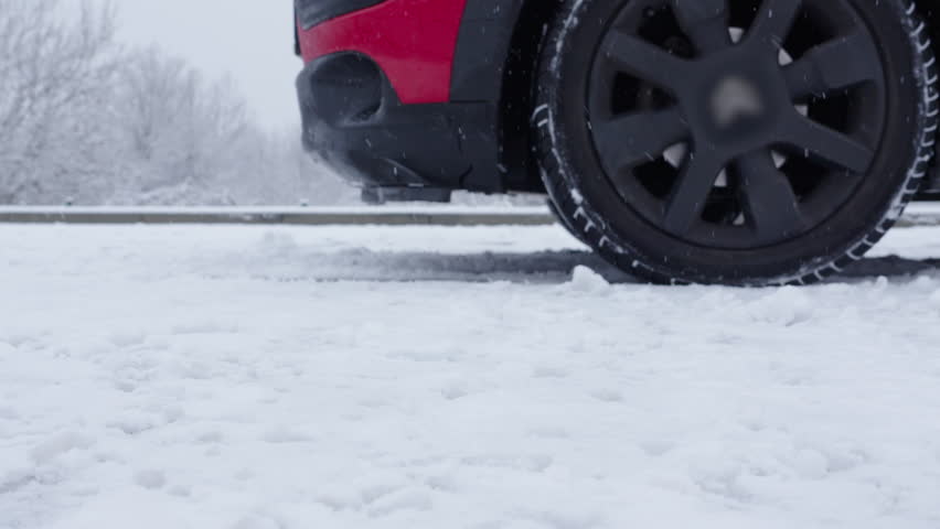 Car braking on icy slope with ABS engaging during a near slide on winter road