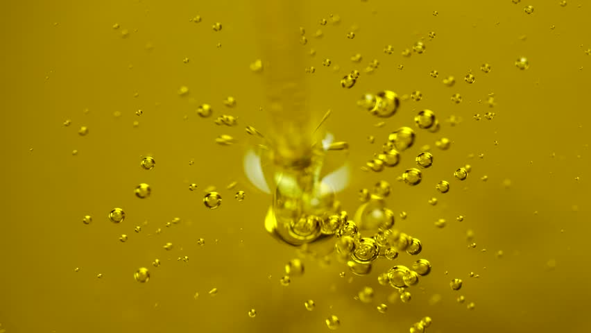 Olive oil jet pours elegantly with visible air bubbles