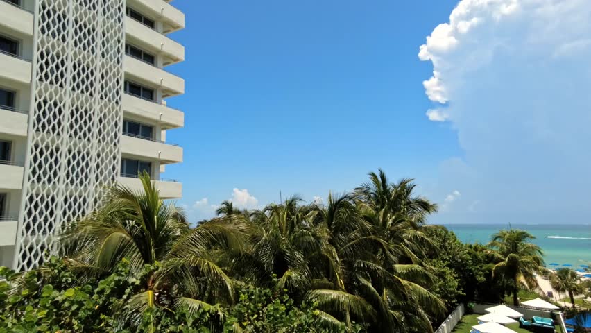 Time lapse view from hotel balcony toward Atlantic Ocean with palm trees and storm clouds on background. Miami Beach. USA.