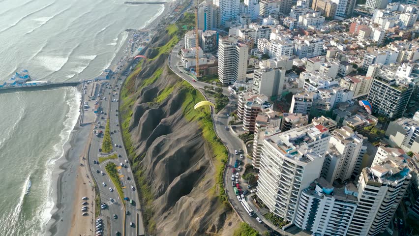 Beautiful aerial view of the Costa Verde in Miraflores, Peru with paragliders on a summer afternoon.