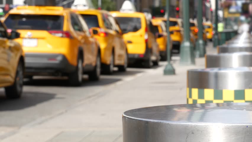 Manhattan Midtown street New York City, United States. Defocused row of yellow taxi cars. Many taxi cabs in line on 8th avenue near Penn Station. Taxi queue, urban road traffic, passenger transport.