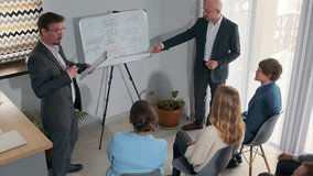 Corporate team engaged in an emotional brainstorming session as two business professionals present ideas on whiteboard. Group collaboration, strategic planning, discussion during office meeting. - Powered by Shutterstock - Get 15% off with code: PIKWIZARD15