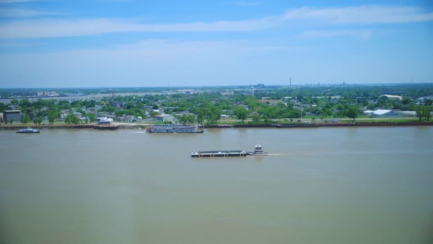 Footage of the Mississippi River with boats and ships sailing, viewed from windows in New Orleans, capturing river traffic and urban scenery.
