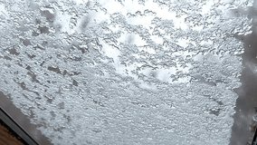 Close-up view of a window covered with a thin layer of snow and frost, forming intricate crystalline patterns on the glass surface in a cold winter setting.
 - Powered by Shutterstock - Get 15% off with code: PIKWIZARD15