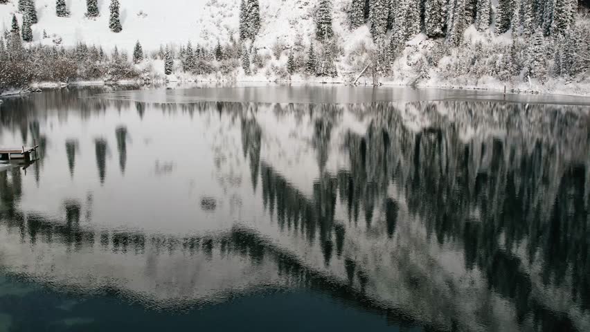 Winter reflections on a calm alpine lake