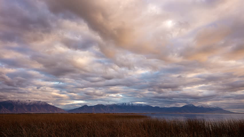 Timelapse panning over Utah Lake during colorful sunset as clouds move through the sky.
