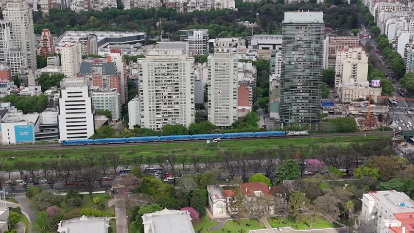 Aerial view of a train in urban Buenos Aires, showcasing city life
