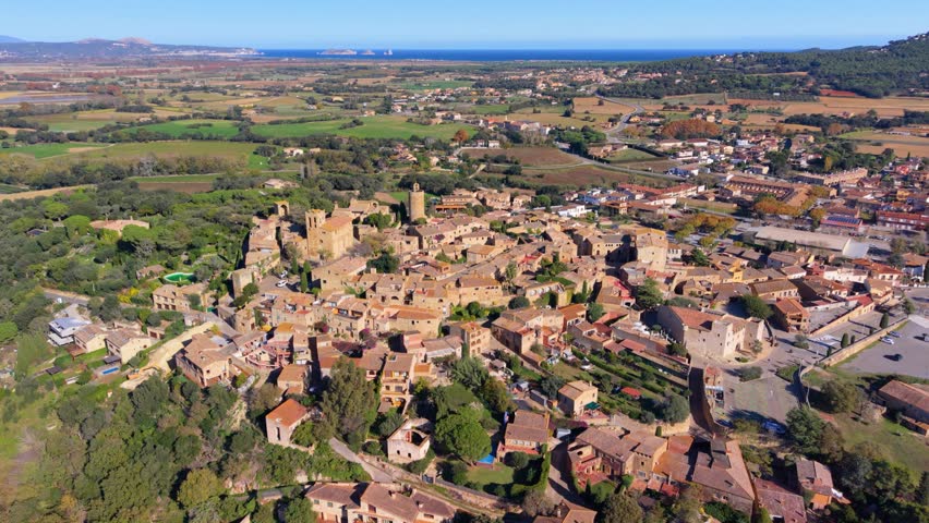 Stunning aerial footage revealing the historic medieval town of pals in costa brava, spain, showcasing its stone architecture, ancient church, and the picturesque mediterranean landscape