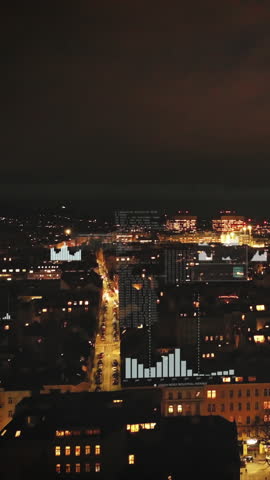 Forwards fly above blocks of residential buildings in large city. Illuminated streets and buildings in evening. Vienna, Austria. Added augmented reality visual effects