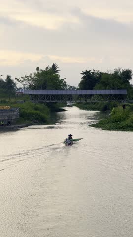 Boat on River Under Bridge, Gorontalo, Indonesia. Fishing boats sail across the river in the afternoon, Gorontalo, Indonesia