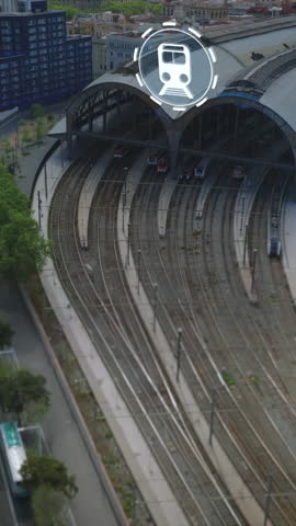 Aerial view of tracks and train station in city near busy multilane road. Computer added visual effects highlighting public transportation. Barcelona, Spain