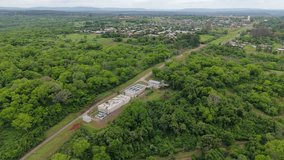 Aerial view of water treatment plant in Misiones, Argentina, surrounded by lush green forest and rural town - Powered by Shutterstock - Get 15% off with code: PIKWIZARD15
