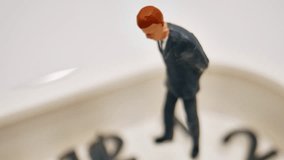 A Miniature Businessman Stands Thoughtfully On A Clock Face, Symbolizing Time Pressure And Business Stress In A Macro Shot. - Powered by Shutterstock - Get 15% off with code: PIKWIZARD15